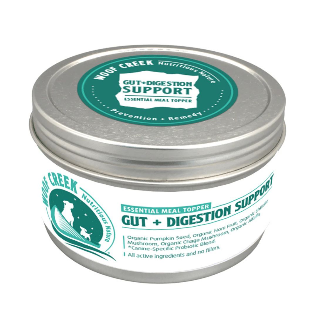 A canister labeled 'Gut+Digestion Support Essential Meal Topper' by WOOF CREEK Nutritious Range.